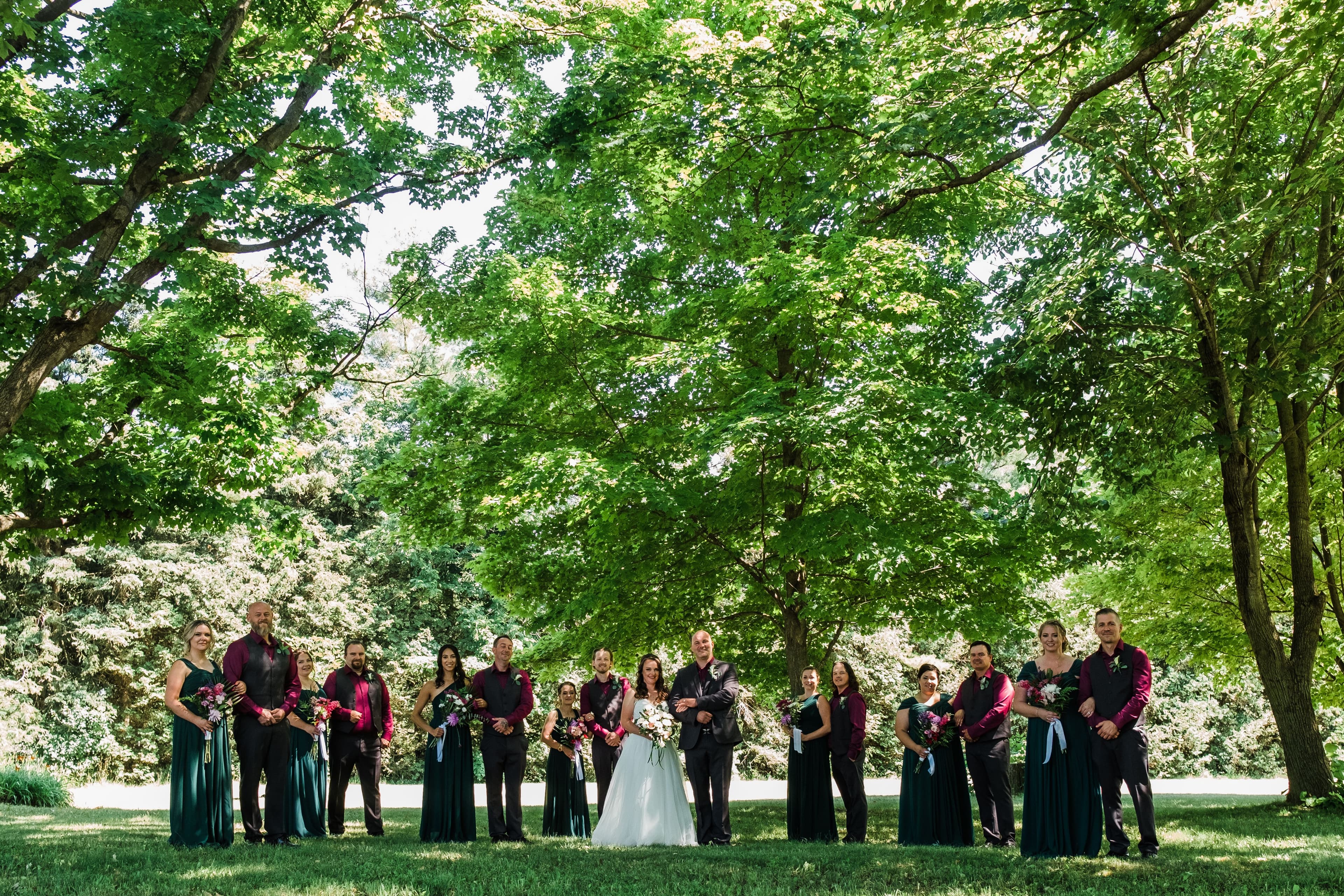 The wedding ring, Waterloo Regional Police Association, BMKH Photography, KW wedding photographer, Waterloo wedding venue, Kitchener wedding venue, Cambridge wedding venue, wedding decor, bridal party standing in a line in a park amoung the trees