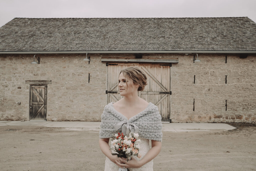 strong like bull, wedding wrap, bride standing in front of barn with warm wall wrap on