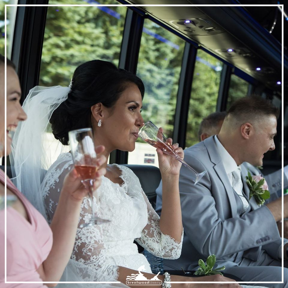 bridal party sipping champagne in the limobus