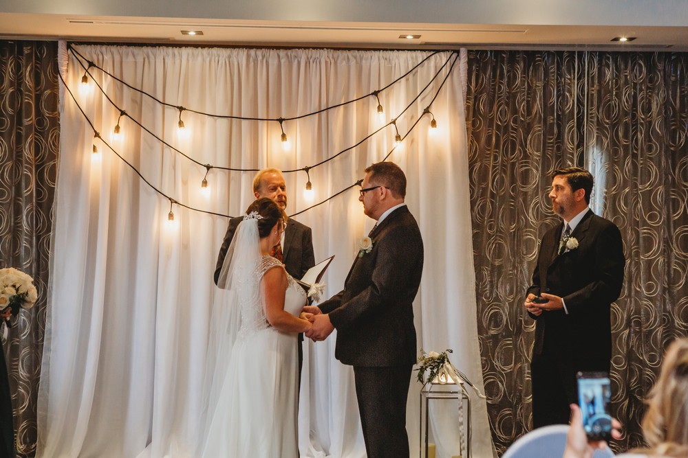 wedding ceremony at delta waterloo Edison lights on a white backdrop