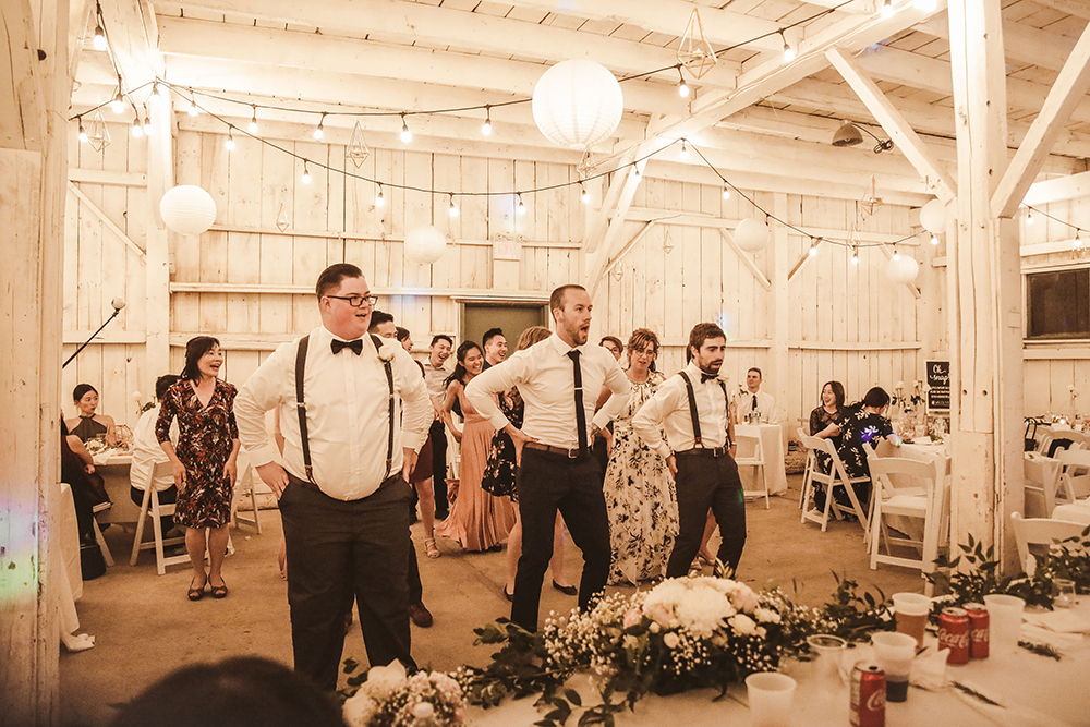 groomsmen dancing at the barn reception at Fanshawe Pioneer Village