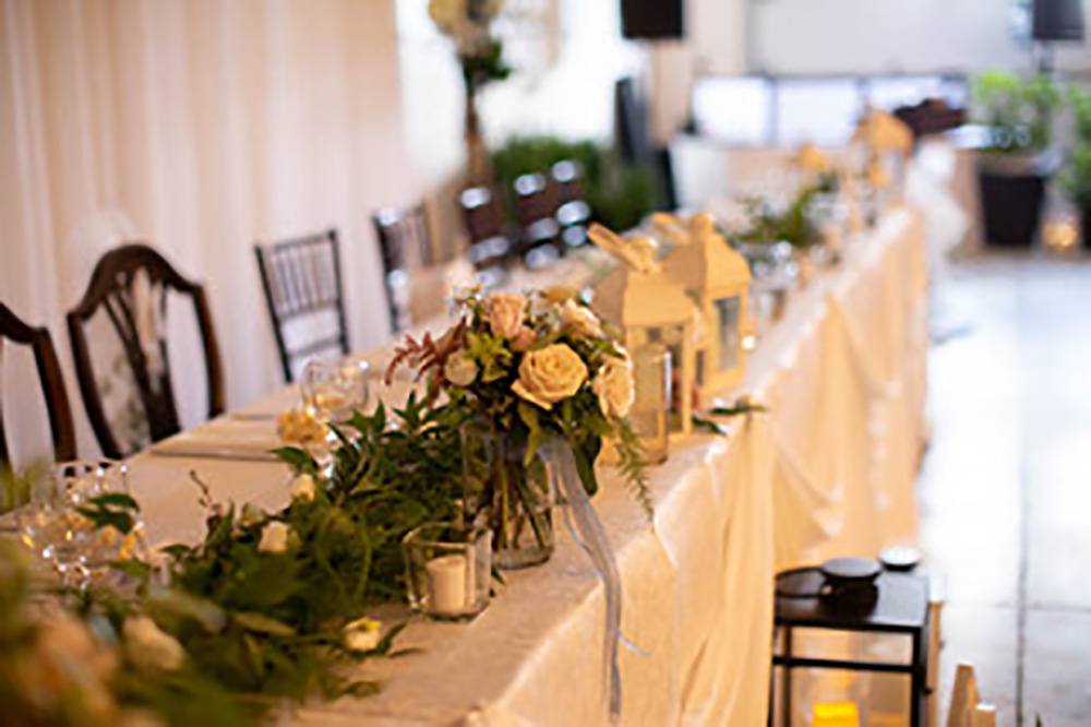 head table with flowers and greenery now & always