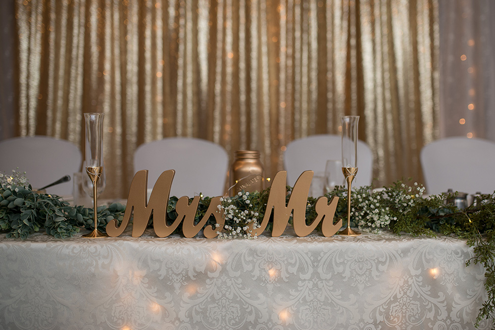 sweatheart table with gold mr & Mrs letters and gold backdrop