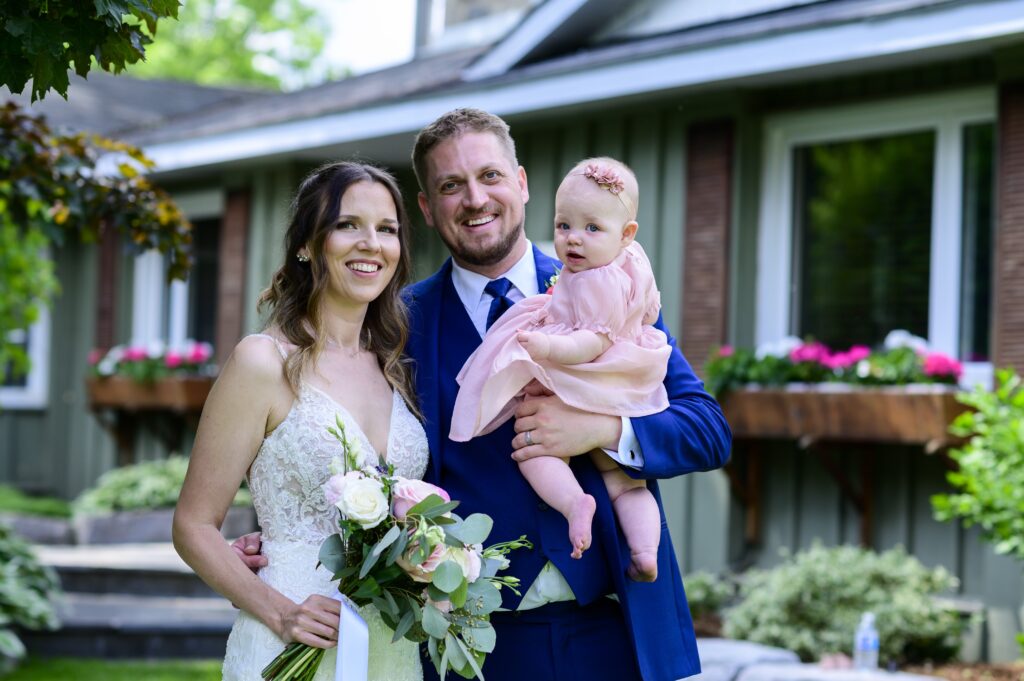 grey silo golf club, the bride and groom holding their daughter looking at the camera