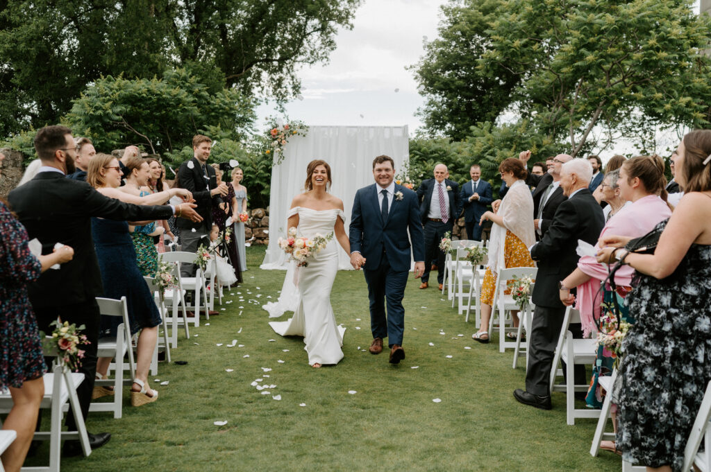 Rebel Creek Golf Club, Colourful Elegance, Bride and Groom holding hands walking up the aisle after saying 'I do'