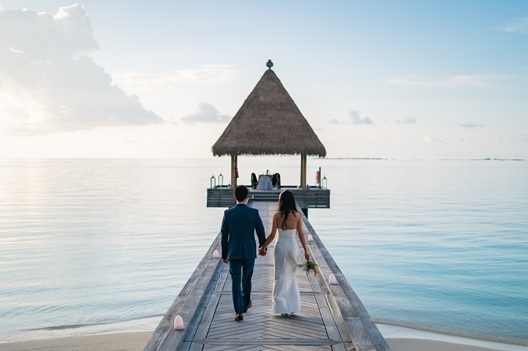 Maldives wedding venues, bride and groom walking on a dock